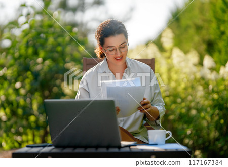 woman working on laptop in summer morning 117167384