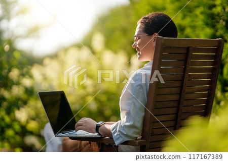 woman working on laptop in summer morning 117167389