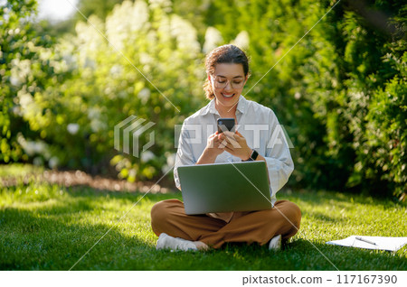 woman working on laptop in summer morning 117167390