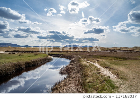 The stream that flows from Sheskinmore Nature Reserve to Ballinravey Strand between Ardara and Portnoo in Donegal - Ireland 117168037