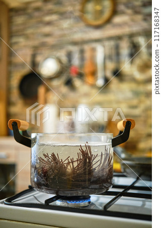 Black rice noodles boiling in saucepan on a gas stove 117168347