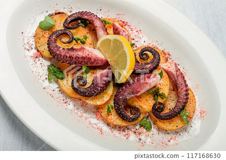 Octopus with potatoes and spices , on a light plate, top view, no people, homemade, close-up, Octopus with potatoes and spices , on a light plate, top view, no people, homemade, close-up, 117168630