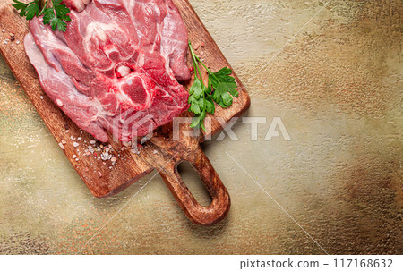 raw steak, veal neck on the bone, fresh meat, on a cutting board, with spices, top view, without people, 117168632