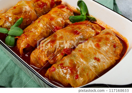 Stuffed cabbage rolls with minced meat, in tomato sauce, top view, without people, in the spotlight. 117168633