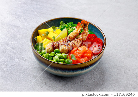 Poke bowl with salmon, shrimps and vegetables. Traditional Hawaiian raw fish salad. Top view 117169240