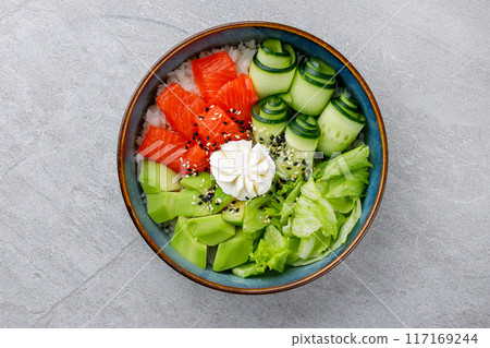 Hawaiian salmon poke bowl with avocado, Top view, gray background Hawaiian salmon poke bowl with avocado, Top view, gray background 117169244