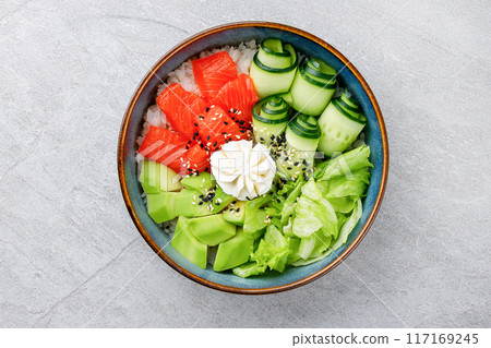 Hawaiian salmon poke bowl with avocado, Top view, gray background Hawaiian salmon poke bowl with avocado, Top view, gray background 117169245