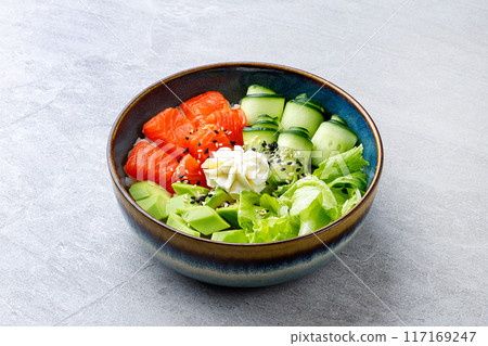 Hawaiian salmon poke bowl with avocado, Top view, gray background Hawaiian salmon poke bowl with avocado, Top view, gray background 117169247
