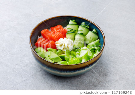 Hawaiian salmon poke bowl with avocado, Top view, gray background 117169248