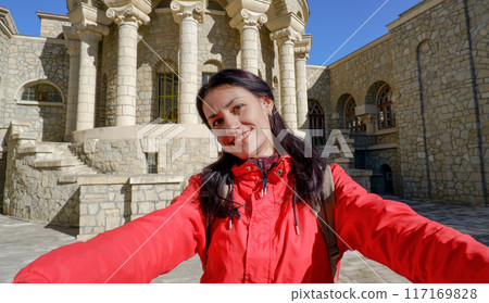 A happy tourist takes a selfie with a smartphone camera in front of the Semashko mud baths, Russia. Mudbath named after Semashko. Built in 1913-1915. Essentuki, Stavropol Territory, Russia. A happy tourist takes a selfie with a smartphone camera in front of the Semashko mud baths, Russia. Mudbath named after Semashko. Built in 1913-1915. Essentuki, Stavropol Territory, Russia. 117169828