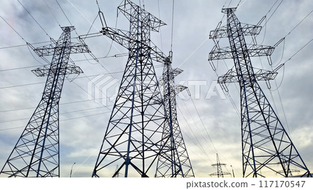 Several high voltage power lines against a dramatic cloudy sky. 117170547