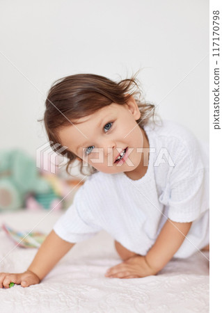 smiling cute little baby girl in white t-shirt playing in her room smiling cute little baby girl in white t-shirt playing in her room 117170798
