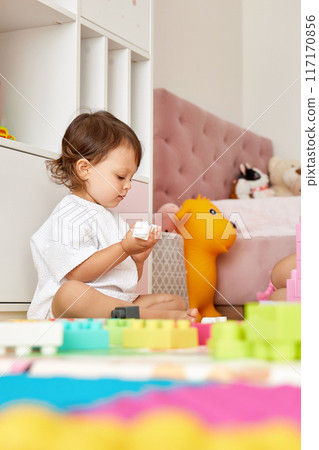 cute baby girl playing with colorful toys bricks at home 117170856