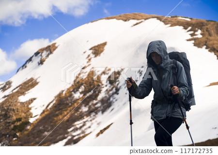 Girl is hiking in the snowy mountains. 117172735