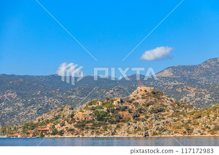View of ancient Lycian town Simena with fortress on a mount on the coast of the Mediterranean sea in Antalya Province, Turkey 117172983