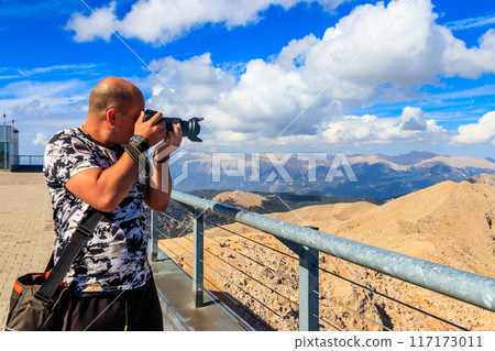 Travel photographer man with professional camera taking photos of on a top of Tahtali mountain near Kemer, Antalya Province in Turkey Travel photographer man with professional camera taking photos of on a top of Tahtali mountain near Kemer, Antalya Province in Turkey 117173011