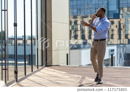 African American businessman using mobile phone in city street 117173803