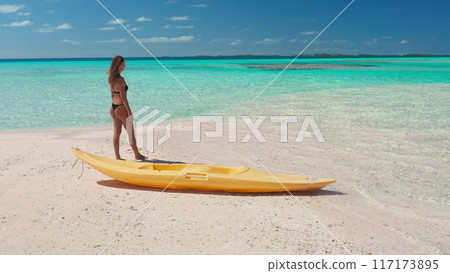 Beautiful girl in bikini sun tan relax on beach, yellow kayak, sea turquoise sea waves. Tropical island nature landscape, sunny day. Active outdoor lifestyle sports, travel on summer holiday vacation 117173895