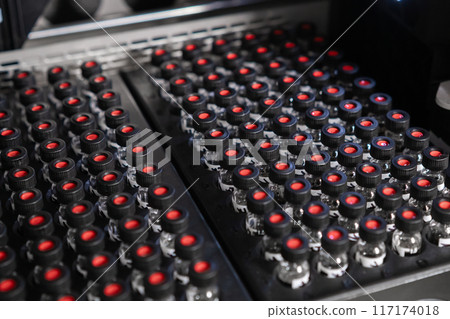 Autosampler picks up a vial with a black cap and collects samples before injecting them for HPLC analysis. Autosampler picks up a vial with a black cap and collects samples before injecting them for HPLC analysis. 117174018