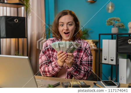 Business woman holding fan of cash money dollar banknotes celebrate success career lottery jackpot Business woman holding fan of cash money dollar banknotes celebrate success career lottery jackpot 117174041