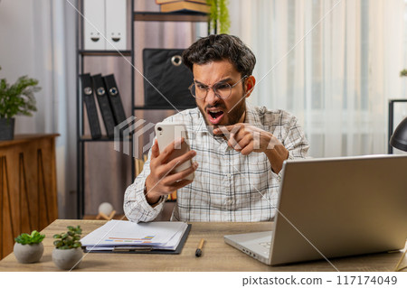 Furious annoyed angry businessman freelancer engage in heated phone quarrel conversations at office 117174049