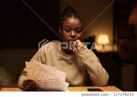 Young troubled woman with unpaid bills 117174215