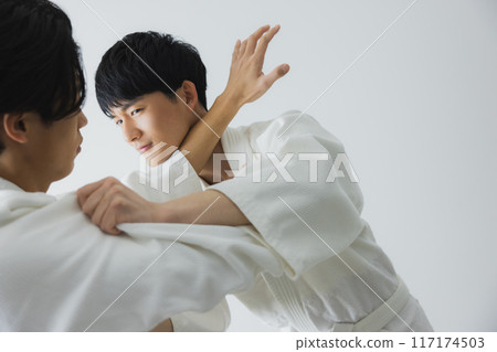 Men in judo uniforms sparring 117174503