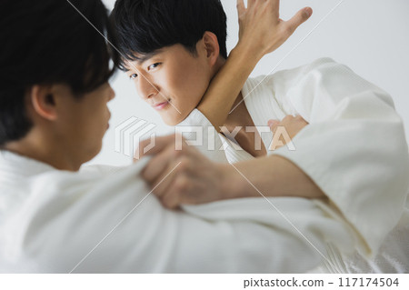 Men in judo uniforms sparring 117174504