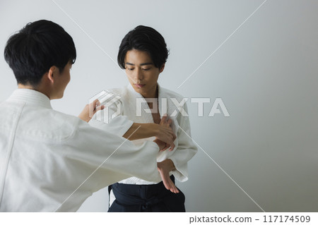 Men in judo uniforms sparring 117174509