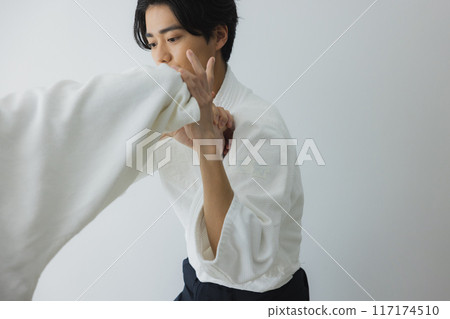 Men in judo uniforms sparring 117174510