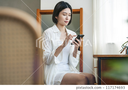 一位女士在智慧型手機上尋找美容資訊 117174693