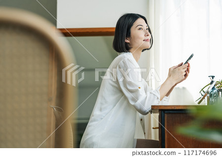 A woman searching for beauty information on her smartphone 117174696