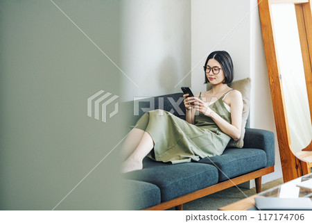 在家沙發上看智慧型手機的女人 117174706