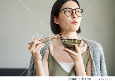 Woman eating at home 117174748