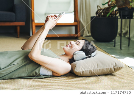 Woman listening to music on smartphone Woman listening to music on smartphone 117174750