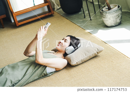 Woman listening to music on smartphone 117174753