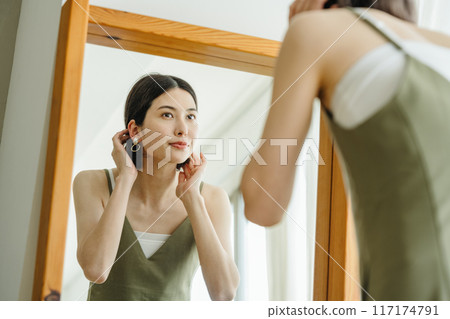 A woman getting ready in the mirror 117174791