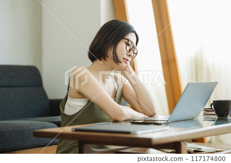 A woman staring blankly at a computer A woman staring blankly at a computer 117174800