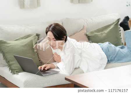 觀看有沙發的婦女一台計算機 117176157