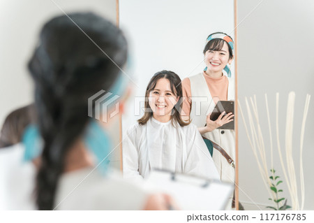 A hairdresser counseling a female customer who consults about hairstyles and hairstyles at a beauty salon / hair salon A hairdresser counseling a female customer who consults about hairstyles and hairstyles at a beauty salon / hair salon 117176785