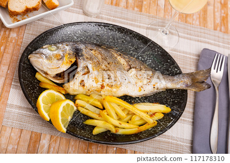 Baked dorado with potatoes on plate Baked dorado with potatoes on plate 117178310