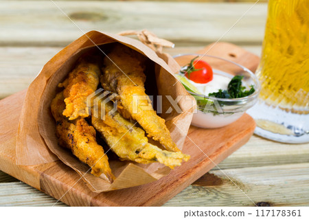 Fish and chips with creamy cheese sauce 117178361