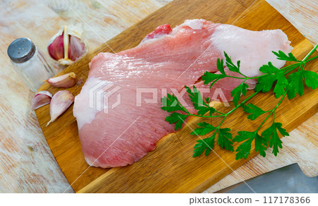 Raw pork secreto fillet and condiments prepared for roasting on wooden cutting board 117178366