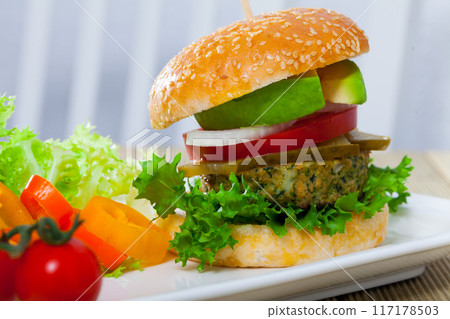 Vegetarian hamburger with soybean patty, tomato, avocado and cucumber Vegetarian hamburger with soybean patty, tomato, avocado and cucumber 117178503