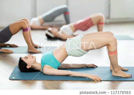 Young girl practicing bridge position with soft ball 117178563