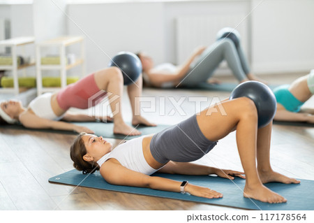 Group of young women doing pilates with softball 117178564