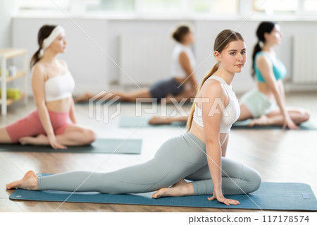 Group of young women doing yoga in studio Group of young women doing yoga in studio 117178574