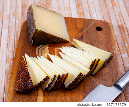 Slices of semi-hard spanish sheep cheese on desk Slices of semi-hard spanish sheep cheese on desk 117178579