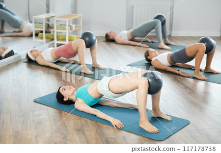 Young girls practicing bridge position with soft ball 117178738