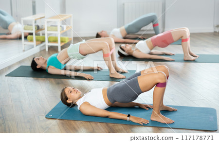 Group of young women doing pilates with band 117178771